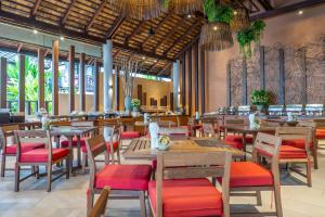 a restaurant with wooden tables and red chairs at Ao Prao Resort in Ko Samed