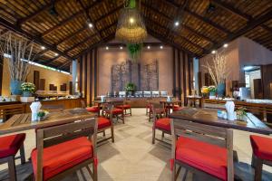 サメット島にあるアオ プラオ リゾートの木製テーブルと赤い椅子が備わるレストラン