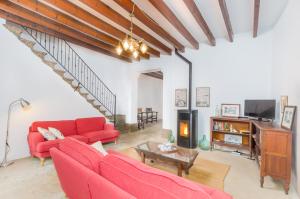 a living room with red couches and a fireplace at Can Romaguera in Algaida