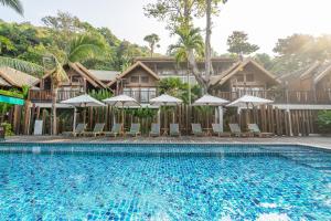 a pool at a resort with chairs and umbrellas at Ao Prao Resort in Ko Samed