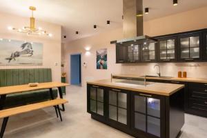 a kitchen with black cabinets and a wooden table at Apartment A.B.S. Secret Oasis in Zagreb