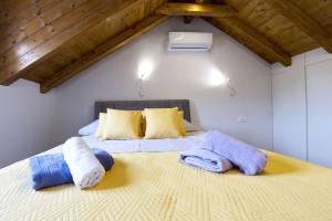 a bedroom with a large bed with towels on it at Apartmani Klara in Stomorska