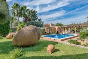 una casa con piscina y un patio con troncos en Cas Mostatxet (Sencelles), en Sencelles