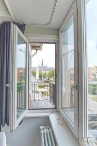 a room with two windows and a balcony at Apartments Villa Manalou in Wenduine