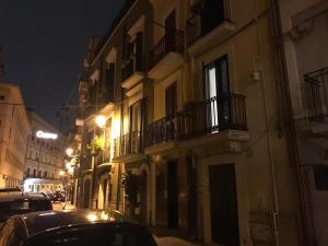 una strada di città di notte con auto parcheggiate accanto agli edifici di Apulia 35 a Bari