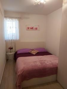a bedroom with a large bed with purple sheets at Apartmant Angel Wings in Omiš