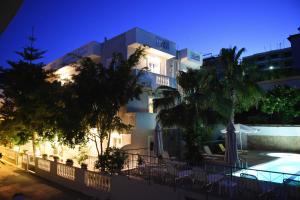 a building with a swimming pool at night at Skalidis Apartments in Tolo