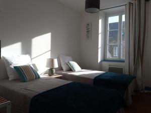 two beds in a room with a window at Gîte la presqu'ile in Portbail