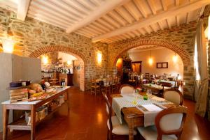 Castello Di Gargonza في مونتي سان سافينو: مطعم فيه طاولات وكراسي في الغرفة