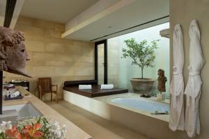 a bathroom with a large tub with a tree in it at Verdura Resort in Ribera