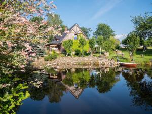 a house sitting on top of a body of water at Agroturystyka Przylesie in Wolimierz