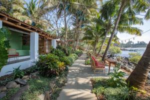 a pathway leading to a house with palm trees at Casa Jaali in Patnem