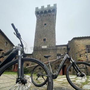 una bicicleta estacionada frente a un castillo en Castello Di Gargonza en Monte San Savino
