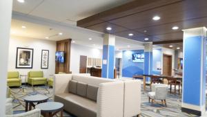 a lobby with a couch and tables and chairs at Holiday Inn Express & Suites - Dallas Market Center, an IHG Hotel in Dallas