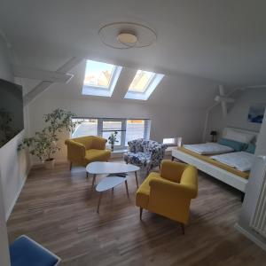 a living room with yellow chairs and a bed at Gästezimmer Treuen - Bed & Breakfast in Treuen