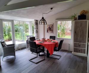 a dining room with a red table and chairs at Vakantiehuis Dartien in Exloo