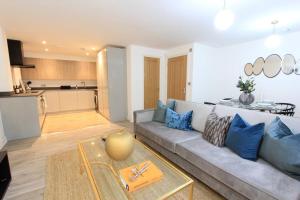 a living room with a gray couch and a kitchen at Cabot Mews Apartment 2 in Bristol