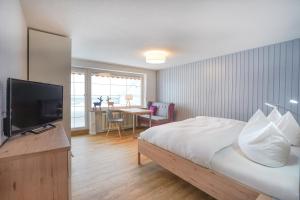 um quarto com uma cama e uma televisão de ecrã plano em Ferienwohnungen Wolter em Oberstdorf
