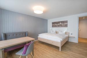 um quarto com uma cama, uma mesa e um banco em Ferienwohnungen Wolter em Oberstdorf