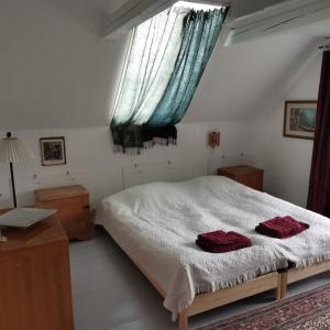 SvebølleMikrogaarden shared kitchen&bathroom的一间卧室配有一张带两个红色毛巾的床