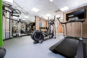 a gym with tread machines and a treadmill at Hotel Great Polonia Kraków Airport in Modlniczka