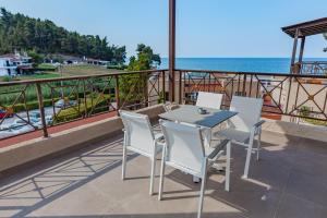 a table and chairs on a balcony overlooking the ocean at Elani Bay Resort in Siviri
