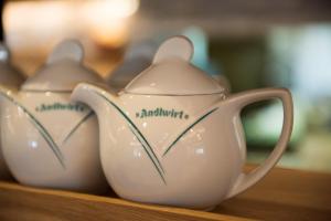 dwa białe garnki do herbaty na drewnianej półce w obiekcie Gasthof Hotel Andlwirt w mieście Sankt Andrä im Lungau