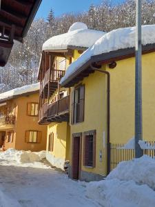 a yellow building with snow on top of it at La Fisarmonica in Valdieri