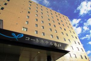 a tall building with a sign in front of it at Court Hotel Mito in Mito