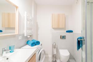 Alvista Apartamenty في ميكلينكي: حمام ابيض مع مرحاض ومغسلة