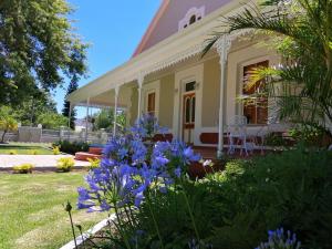 a house with purple flowers in the yard at Monte Rosa Guesthouse in Rawsonville