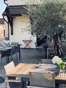 un patio con mesas, sillas y un árbol en HARDY - Cognac & Pension en Valtice