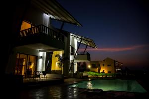 a villa with a swimming pool at night at Soma Vineyard Resort -Nashik in Nashik