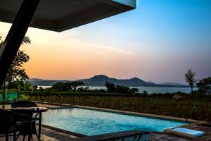 a pool with a view of the water and mountains at Soma Vineyard Resort -Nashik in Nashik