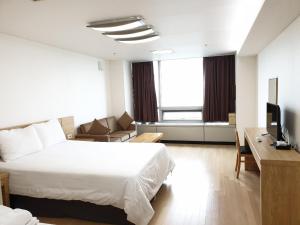 仁川的住宿－愛特爾好日子旅館，酒店客房配有床、沙发和电视。