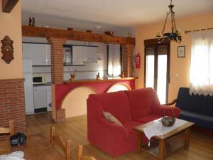 un soggiorno con divano rosso e camino di Casa el Tío Enrique a Cazorla