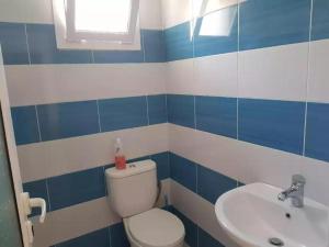 a blue and white bathroom with a toilet and a sink at PENELOPE 2 in Dhërmi
