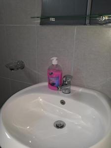 - un lavabo dans la salle de bains avec une bouteille de savon dans l'établissement PENELOPE 2, à Dhërmi