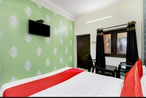 鲁德拉普尔Hotel kingsman的一间卧室，墙上有一张床和一台电视