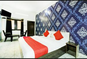 a bedroom with a large bed with red pillows at Hotel kingsman in Rudrapur