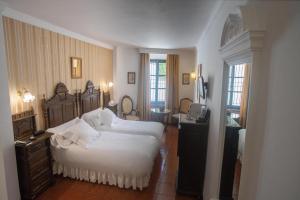 a hotel room with two beds and a desk at Hotel Soho Boutique Palacio San Gabriel in Ronda