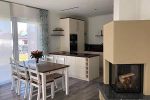 a kitchen and dining room with a table and a fireplace at Annas Home II in Sassenburg