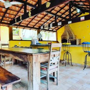 eine Küche mit einem großen Holztisch und Stühlen in der Unterkunft Pousada Lele do Pero in Cabo Frio