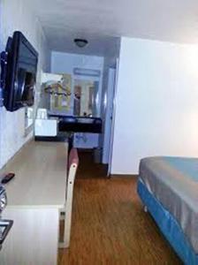 Habitación con cama, escritorio y TV. en Motel 6-Carlsbad, NM, en Carlsbad