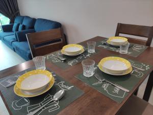 uma mesa de jantar com pratos e utensílios em Cozzyhome@REX BDC em Kuching