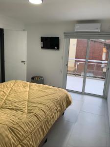 Un dormitorio con una cama y vista a un edificio. en Complejo Los Cardenales, en Monte Hermoso