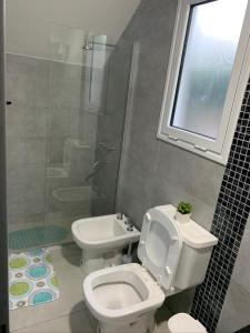 Un baño con inodoro, lavabo y ventana. en Complejo Los Cardenales, en Monte Hermoso 4 fotos más