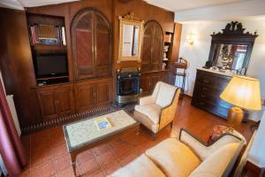 - un salon avec un canapé, des chaises et une télévision dans l'établissement Hotel Soho Boutique Palacio San Gabriel, à Ronda