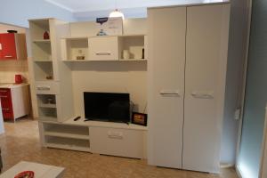 a living room with a tv and a white cabinet at Éva Apartman in Szigetvár