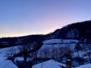 a snow covered hill with trees and a mountain at Il Sogno nel Vento in Tufo Basso